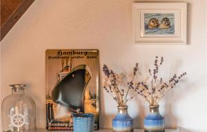 a shelf with vases and a picture of two dogs at Cozy Apartment In Friedrichskoog-Spitze in Friedrichskoog-Spitz +6 photos
