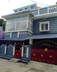 una casa blu con un cancello davanti di Aarudhara Holiday Home (A Home away from Home) a Pondicherry