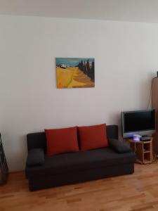 ウィーンにあるThe White Apartmentのリビングルーム(黒いソファ、テレビ付)
