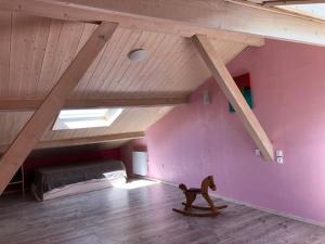 a room with a purple wall with a toy horse on a skateboard at Maison avec piscine couverte Pilat Ardèche in Saint-Sauveur-en-Rue