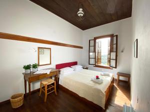 1 dormitorio con cama y escritorio. en Alatinos, en Pinakátai