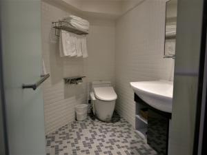 a white bathroom with a toilet and a sink at 泊居旅店二館 Oursinn Hotel 2 in Taipei