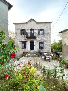 an old stone house with a patio and flowers at Alatinos in Pinakátai