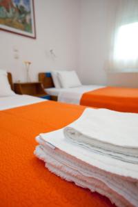 two beds with white towels sitting on a table at Yiouli Hotel in Kókkinon Nerón