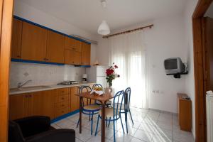 a kitchen with a table and chairs in a kitchen at Yiouli Hotel in Kokkino Nero