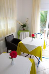 Una habitación con dos mesas con flores. en Yiouli Hotel en Kókkinon Nerón