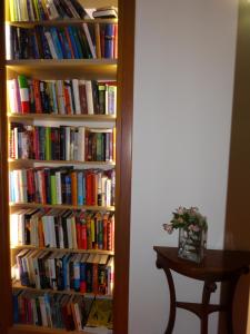 a book shelf filled with books next to a table at Hotel Televrin in Nerezine