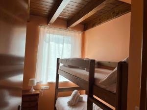 a bedroom with two bunk beds and a window at Casa de poble acollidora,amb llar de foc, in Bourg-Madame