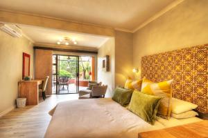 a hotel room with a bed and a couch at La Roca Guest House in Nelspruit +105 photos