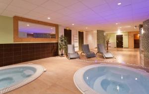 una gran bañera de hidromasaje en una habitación con sillas en Hôtel Club mmv Le Panorama ***, en Les Deux Alpes