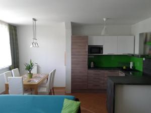 cocina y comedor con mesa y sillas en Apartmán Liptov, en Lúčky