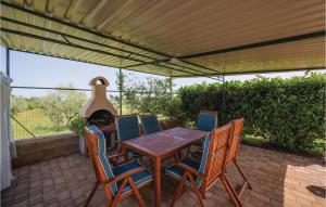 een tafel en stoelen op een patio met een grill bij Stunning Home In Mihatovici With Kitchen in Rošini