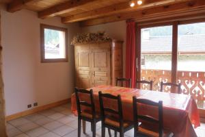 uma sala de jantar com uma mesa e cadeiras e uma janela em Chalet Philippe em Peisey-Nancroix