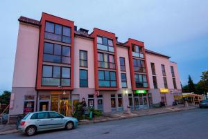 una piccola auto parcheggiata di fronte a un edificio di Apartments and Studios Perunika a Moravske Toplice