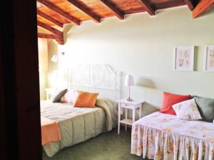 トッリ・デル・ベーナコにあるVilla Margiòのベッドルーム1室(ベッド2台、ランプ付きテーブル付)