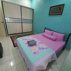 1 dormitorio con cama morada y almohada en Ma Maison Homestay Taman Daiman Jaya Kota Tinggi en Kota Tinggi