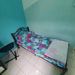 Cama pequeña en habitación azul en Ma Maison Homestay Taman Daiman Jaya Kota Tinggi en Kota Tinggi