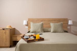 a bed with a tray of food and drinks on it at Hotel Punta San Francesco in Vieste