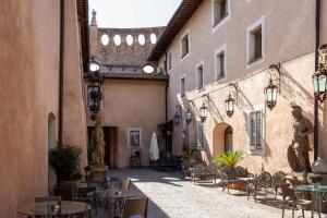 ローマにあるIl Monastero Collectionの建物内のテーブルと椅子のある路地