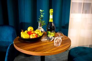a bowl of fruit and a bottle of wine on a table at Hotel Das Zeit in Lenzing