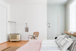 ブダペストにあるHerbarium Apartmentの白いベッドルーム(ベッド1台、椅子付)
