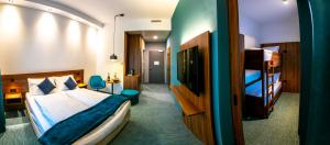 a hotel room with a bed and a tv at Hotel Das Zeit in Lenzing