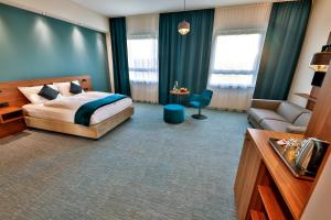a hotel room with a bed and a couch at Hotel Das Zeit in Lenzing