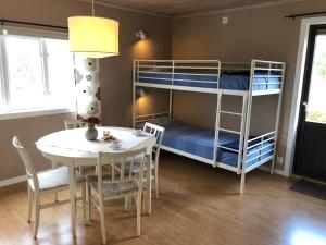 ForserumにあるGården Ekönのテーブルと二段ベッドが備わる客室です。