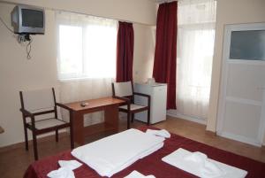 a hotel room with a bed and a table and chairs at Hotel Laguna in Eforie Nord