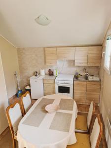 a small kitchen with a white table and chairs at Forest Apartment in Nikšić