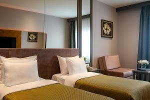 a hotel room with two beds and a chair at Oran Hotel in Istanbul