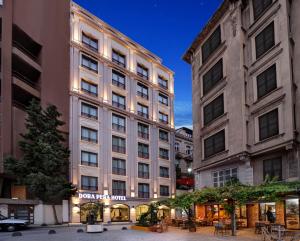 a large building with tables and chairs in front of it at Dora Pera Hotel in Istanbul