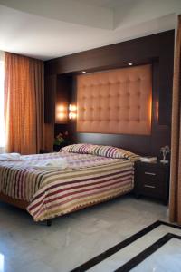 a bedroom with a large bed with a large headboard at Lito Beach Hotel in Gerani