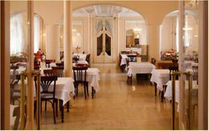 a dining room with white tables and chairs in a restaurant at Hôtel Métropole in Lourdes +19 photos