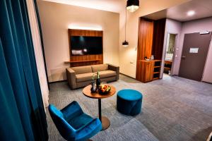 a living room with a couch and a table and chairs at Hotel Das Zeit in Lenzing