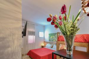 a vase of flowers on a table in a room at Calasole Country House in Torre Lapillo
