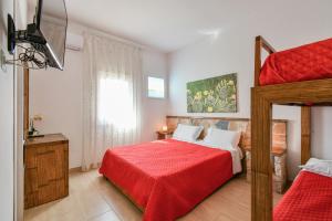 a bedroom with two bunk beds and a red blanket at Calasole Country House in Torre Lapillo
