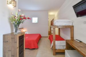 a bedroom with a bunk bed and a vase of flowers at Calasole Country House in Torre Lapillo