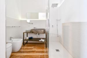 a bathroom with a sink and a tub and a toilet at Calasole Country House in Torre Lapillo
