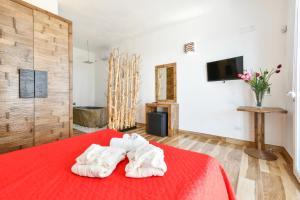 a room with a bed with a red blanket at Calasole Country House in Torre Lapillo