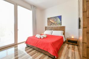 a bedroom with a bed with a red blanket at Calasole Country House in Torre Lapillo