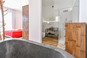 a bathroom with a bath tub and a bedroom at Calasole Country House in Torre Lapillo