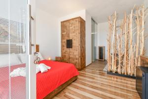 a bedroom with a red bed and wooden floors at Calasole Country House in Torre Lapillo