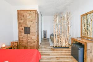 a room with a red bed and a wooden wall at Calasole Country House in Torre Lapillo
