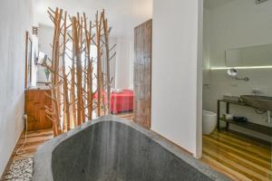 a bathroom with a tub in the middle of a room at Calasole Country House in Torre Lapillo