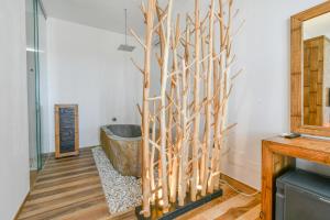a bathroom with a tree root wall at Calasole Country House in Torre Lapillo