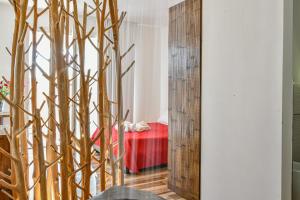 a mirror in front of a bedroom with a red bed at Calasole Country House in Torre Lapillo