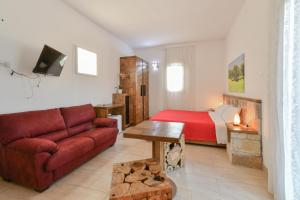 a living room with a couch and a bed at Calasole Country House in Torre Lapillo