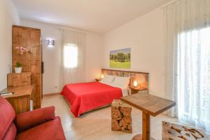 a bedroom with a bed with a red blanket at Calasole Country House in Torre Lapillo