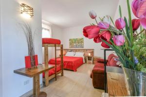 a living room with a bed and flowers in a room at Calasole Country House in Torre Lapillo